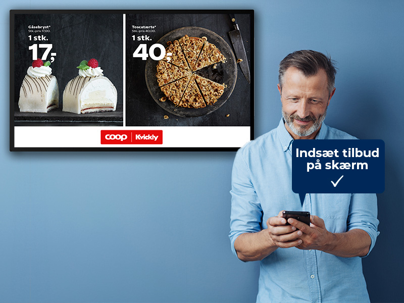 Mand placeret på en blå baggrund står med sin mobiltelefon i hånden og kigger på skærmen der viser tilbud på kage og tærte
